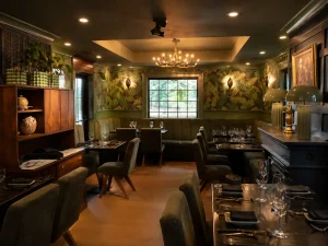 Warm dining room with green botanical décor and set tables